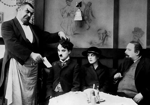 چارلی چاپلین در فیلم "مهاجر" (۱۹۱۷) − رفتن به رستوران هزینه دارد. کنش تراطبقاتی مشکل و پر هزینه است.