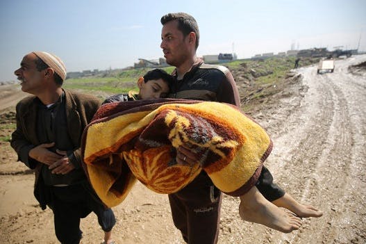 تصویر یک جنگ‌زده موصل بدن بی‌جان پسرش را که در جریان حمله نیروهای عراقی به داعش کشته شده، حمل می‌کند