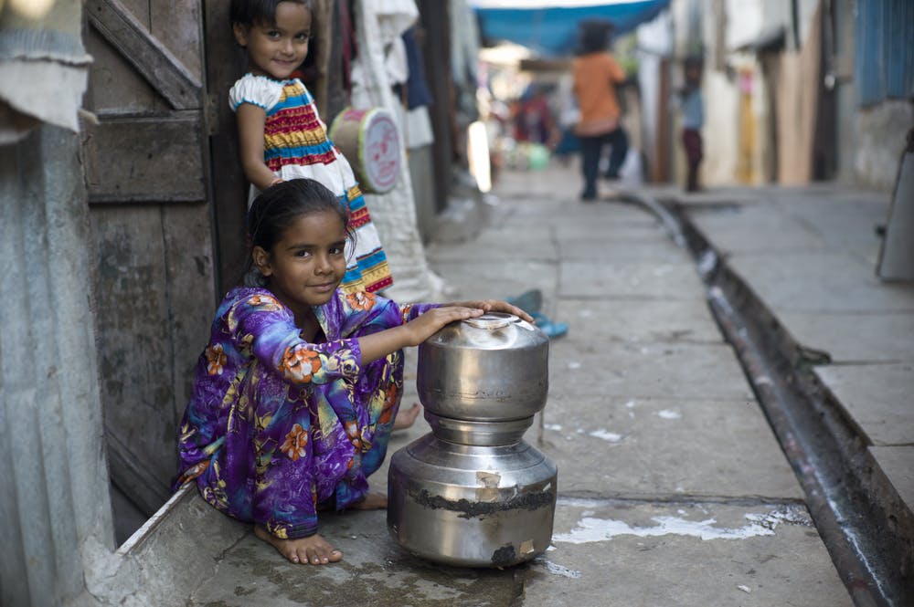 کودکان در مناطق فقیرنشین مومبای (بمبئی سابق) با سطل از چاه آب آشامیدنی به خانه می‌برند.