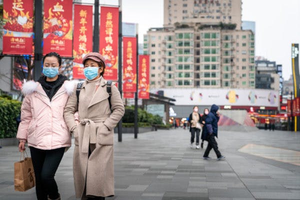 دو نفر در حال قدم زدن در خیابانی در پکن
