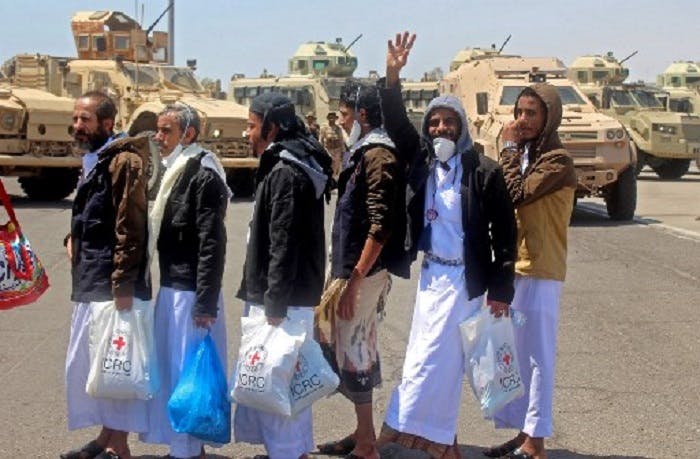 International Red Cross workers and Yemeni officials coordinate as prisoners walk towards a plane used to carry them to the rebel-held capital Sanaa, at an airport in the southern city of Aden, the interim seat of the Yemeni government, on October 16, 2020, as the war-torn country began swapping 1,000 prisoners in a complex operation overseen by the International Committee of the Red Cross. - Over 170 former prisoners of war were freed today on the second day of a landmark exchange between war-torn Yemen's government and Huthi rebels, the International Committee of the Red Cross said. A plane from the southern city of Aden, the interim seat of the Yemeni government, took 101 former prisoners to the rebel-held capital Sanaa, while another aircraft transported 76 detainees in the opposite direction, the ICRC said on Twitter. (Photo by Saleh Al-OBEIDI / AFP)