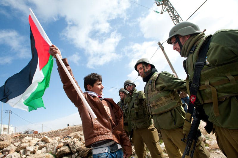 یک فلسطینی ساکن سرزمین‌های اشغالی در برابر سربازان اسرائیلی