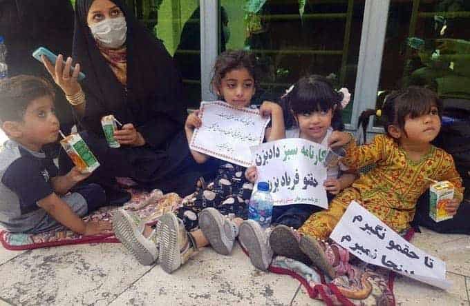 یک معلم از استان سیستان و بلوچستان همراه با کودکان خود در پیاده‌رو جلوی وزارت آموزش و پرورش، ۶ تیر ۱۴۰۰، عکس از سایت ایران کارگر