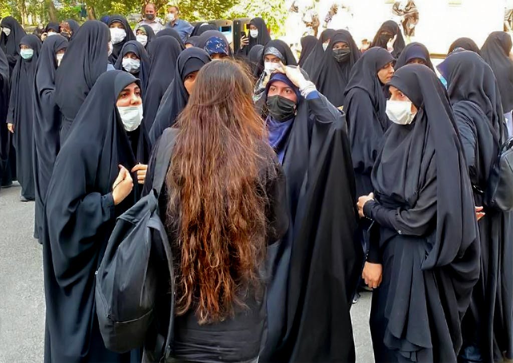 زنی تنها بدون روسری در محاصره زنان چادری