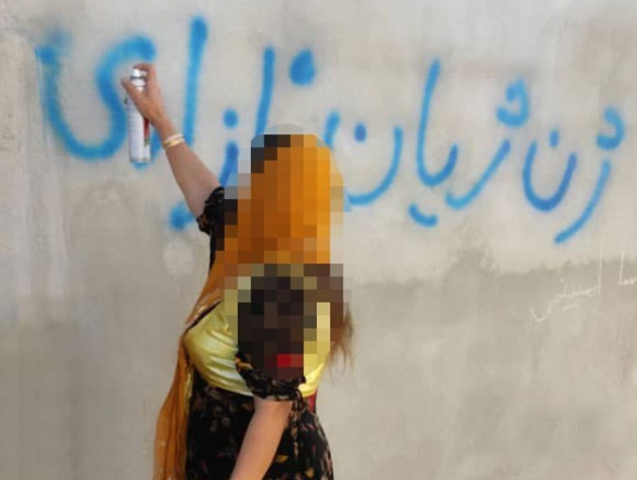 زن معترض کرد در حال نوشتن ژن، ژیان، ئازادی (زن، زندگی، آزادی) ــ عکس: کُردپا