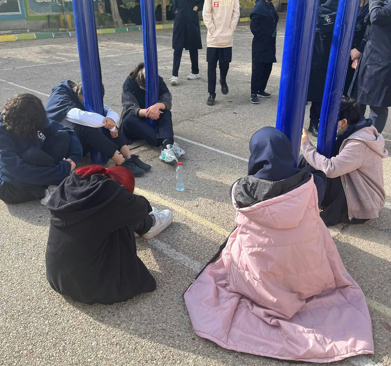 پرفورمنس دانش‌‌آموزان شیرازی برای خدانور لجه‌ای - چند دانش‌آموز دختر روزی زمین نشسته و صحنه بسته شدن خدانور به میله پرچم با دستان بسته را بازسازی کرده‌اند
