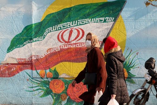 ۲۸ دسامبر ۲۰۲۰: دیوارنگاره‌ای در تهران و رهگذرانی. عکس: خبرگزاری فرانسه