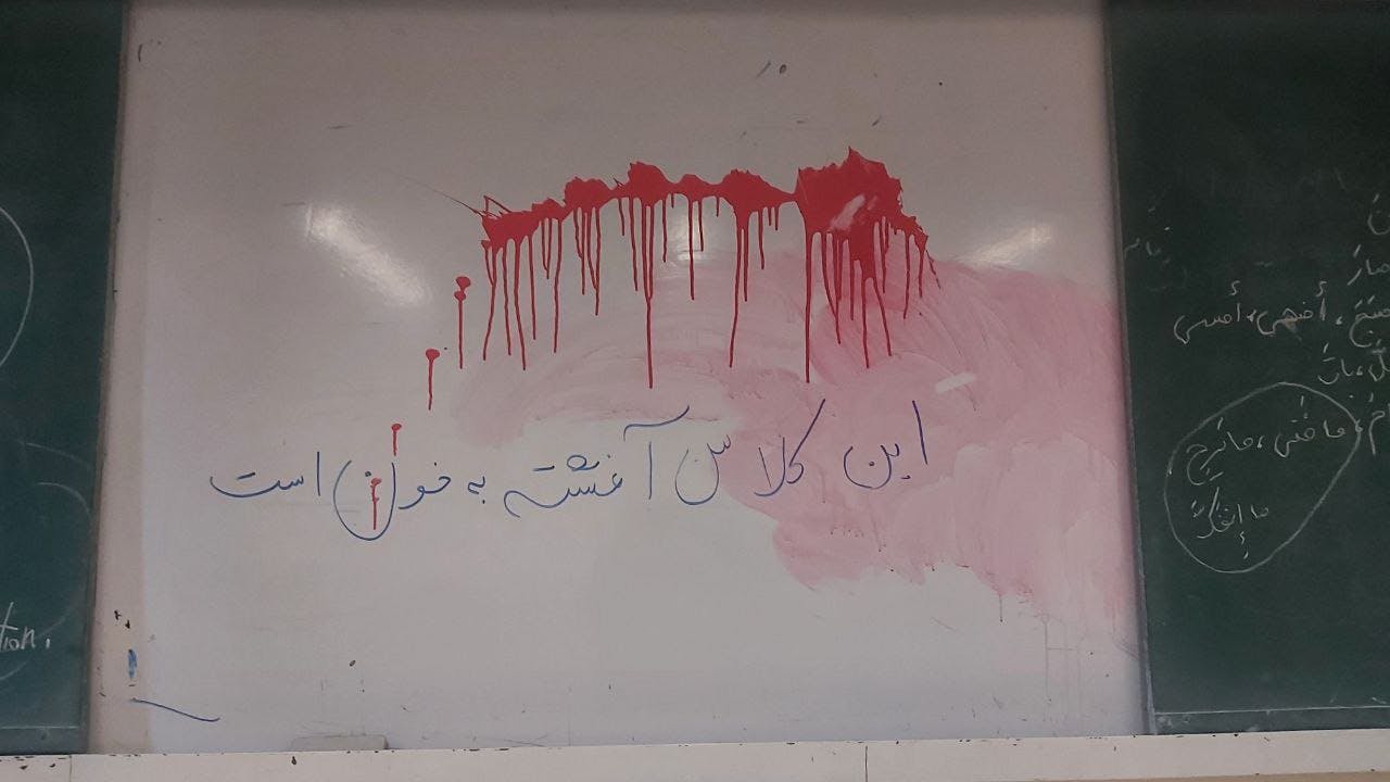 یک کلاس درس در دانشگاه اصفهان. با رنگ سرخ بر وایت‌برد نوشته‌اند این کلاس آغشته به خون است.