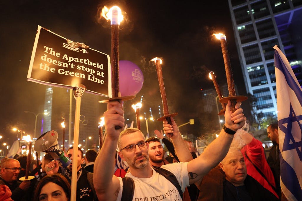 معترضان اسرائیلی مشعل به‌دست در جریان تظاهرات علیه دولت جدید جناح راست نخست وزیر بنیامین نتانیاهو در تل آویو ۲۱ ژانویه ۲۰۲۳