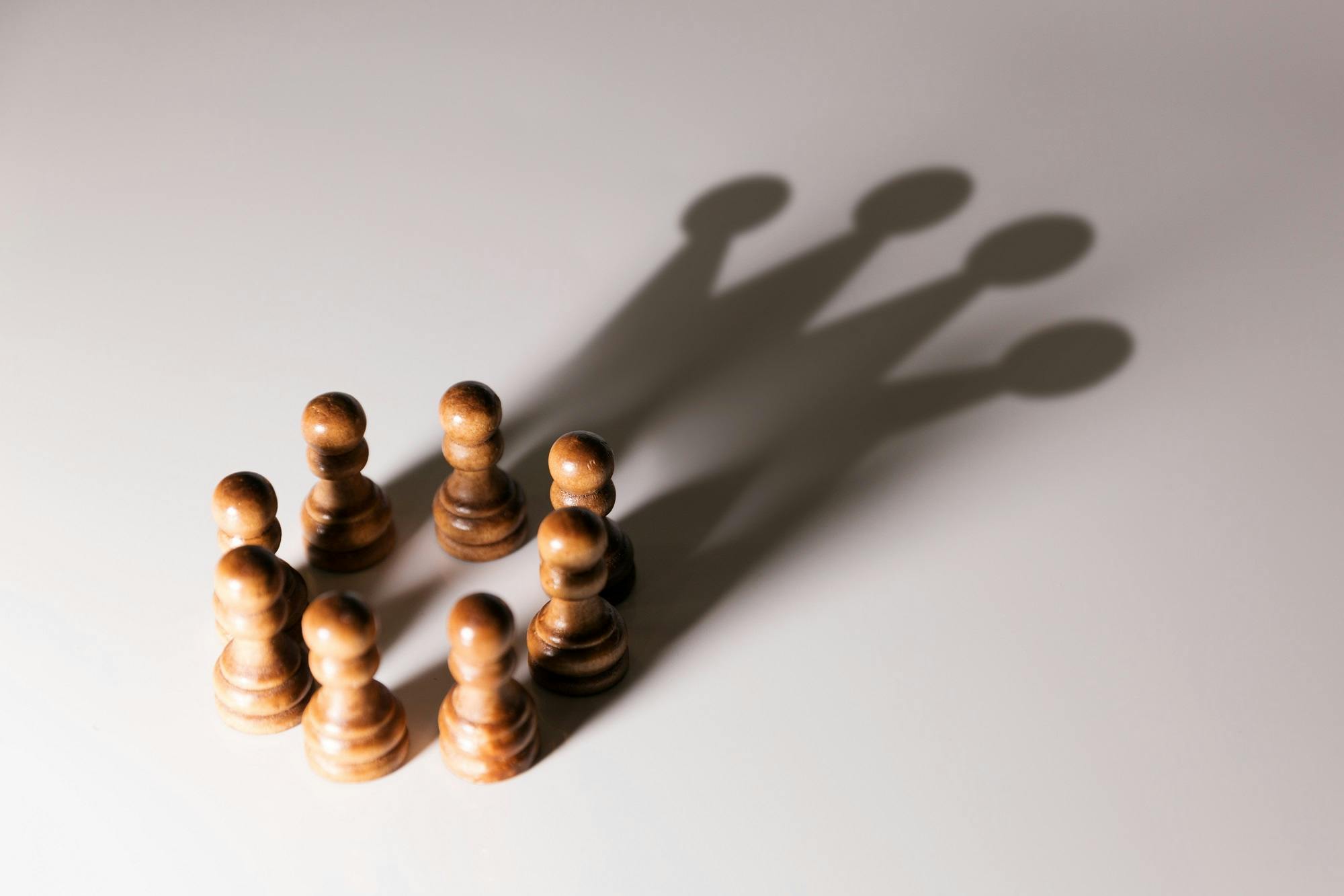تصویری نمادین از ائتلاف از چند مهره شطرنج که سایه‌شان تاجی را تشکیل می‌دهند ــ عکس: شاتراستاک
