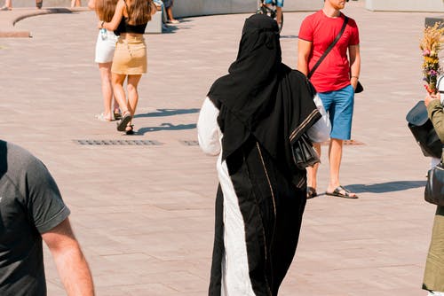 Muslim,Woman,Wearing,White,And,Black,Clothes,Going,Through,The