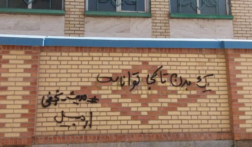 گرافیتی از قیام ژینا، اردبیل. روی دیوار نوشته شده: یک بدن تا کجا تواناست ــ عکس: شبکه‌های اجتماعی