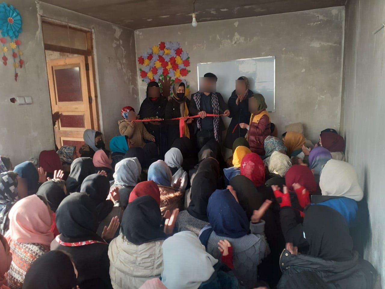 معلم مرد و شاگردان دخترش روبان قرمز افتتاح یک کلاس زیر زمینی آموزش به دختران در نقطه‌ای از افغانستان تحت حکومت طالبان را قیچی می‌کنند