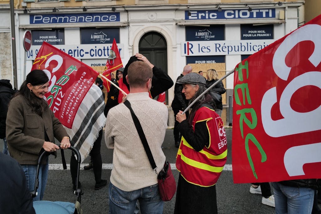 چند نفر از اعضای از اتحادیه کارگری چپ‌گرای CGT پرچم‌های این اتحادیه را در دست دارند و با هم در حال صحبت‌اند.