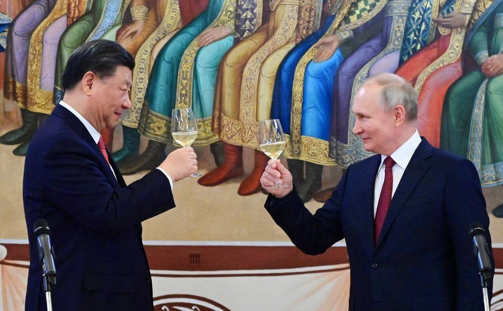 ولادیمیر پوتین، رئیس جمهوری روسیه و شی جین پینگ، رئیس جمهوری چین در ضیافت شام کرملین گیلاس‌های شراب را به سوی هم بلند کرده‌اند و به یکدیگر نگاه می‌کنند و لبخند می‌زنند