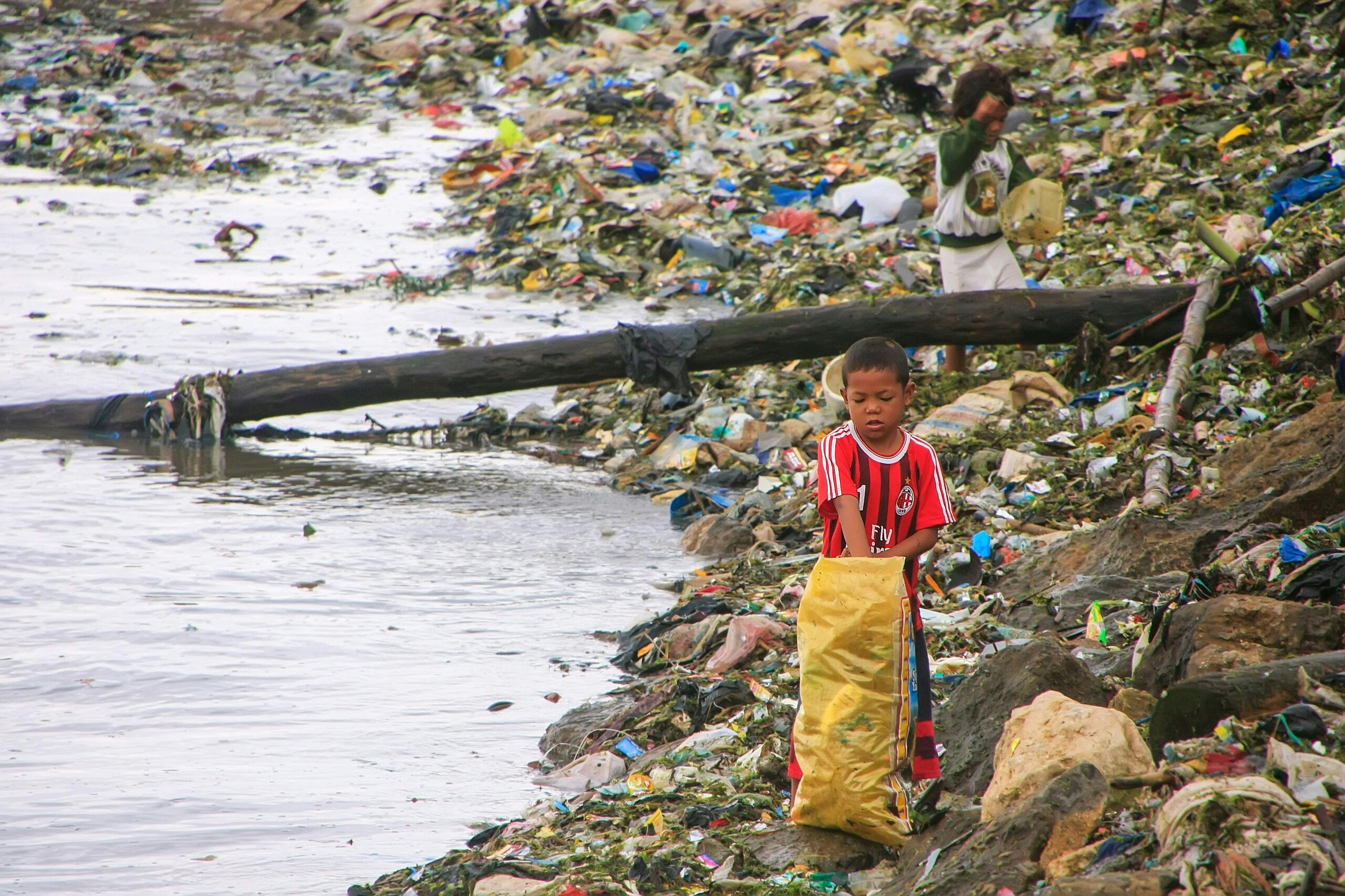 پسران ناشناس در ۱۷ مارس ۲۰۱۲ در سواحل دریا در لابوان باجو، فلورس، اندونزی از زباله ها عبور می کنند.