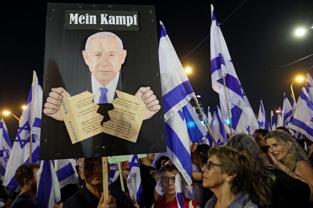 معترضان پرچم اسرائیل را در میان تظاهرات‌های جاری علیه لایحه اصلاحات قضایی دولت در تل آویو در ۸ آوریل ۲۰۲۳ در دست دارند. (عکس از GIL Cohen-MAGEN / AFP)