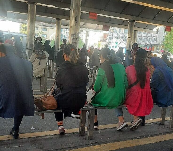گروهی از زنان در ایستگاه اتوبوس حجاب از سر برداشته‌اند