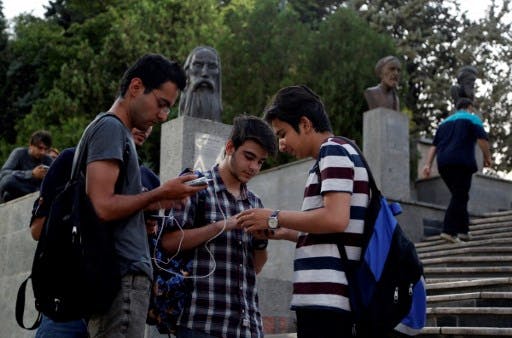 تصویر تزئینی: چند جوان در تهران به تلفن‌های هوشمند خود چشم دوخته‌اند.