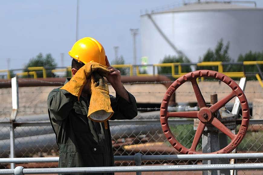 یک کارگر در صنعت نفت در کنار لوله انتقال