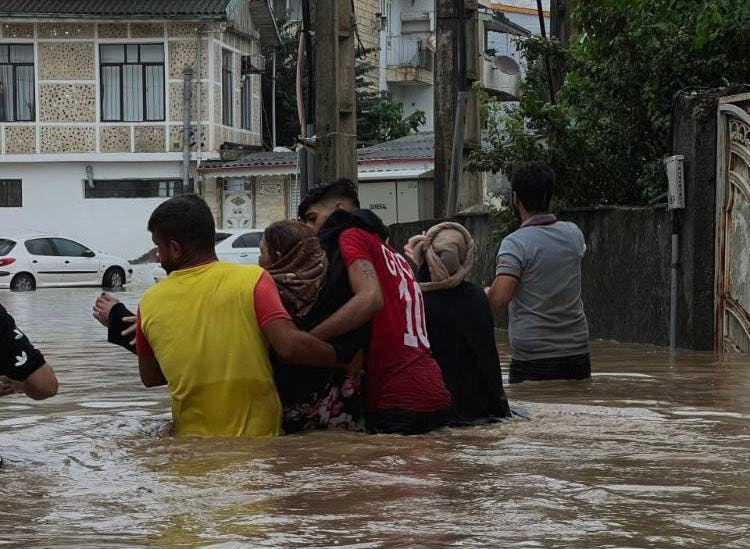 تصویر از شبکه‌های اجتماعی چند نفر را در گذر سیل آستارا و تالش در حال گذر از خیابانی نشان می‌دهد که آب در آن تا کمر آن‌ها بالا آمده است.