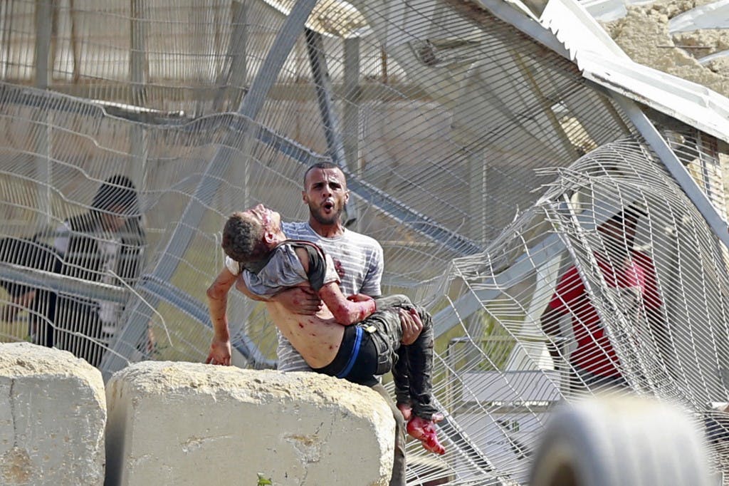 نوار غزه، ۷ اکتبر ۲۰۲۳: یک مرد فلسطینی کودک کشته‌شده‌ای را از میان ویرانه‌های به جا مانده پس از یک حمله هوایی اسرائیل خارج می‌کند. − منبع: AFP