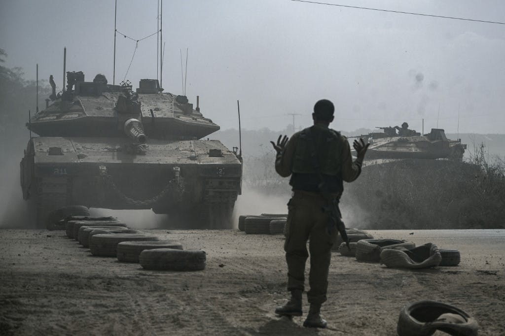 یک سرباز اسرائیلی یک تانک جنگی مرکاوا را هدایت می کند که همراه با تانک های دیگر در امتداد مرز با نوار غزه در جنوب اسرائیل مستقر می شود. تاریخ عکس ۱۳ اکتبر ۲۰۲۳ (عکس از Aris MESSINIS / AFP)