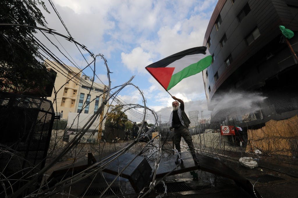 در بیروت مردی پرچم فلسطین را تکان می‌دهد. در مقابل سفارت آمریکا در پایتخت لبنان