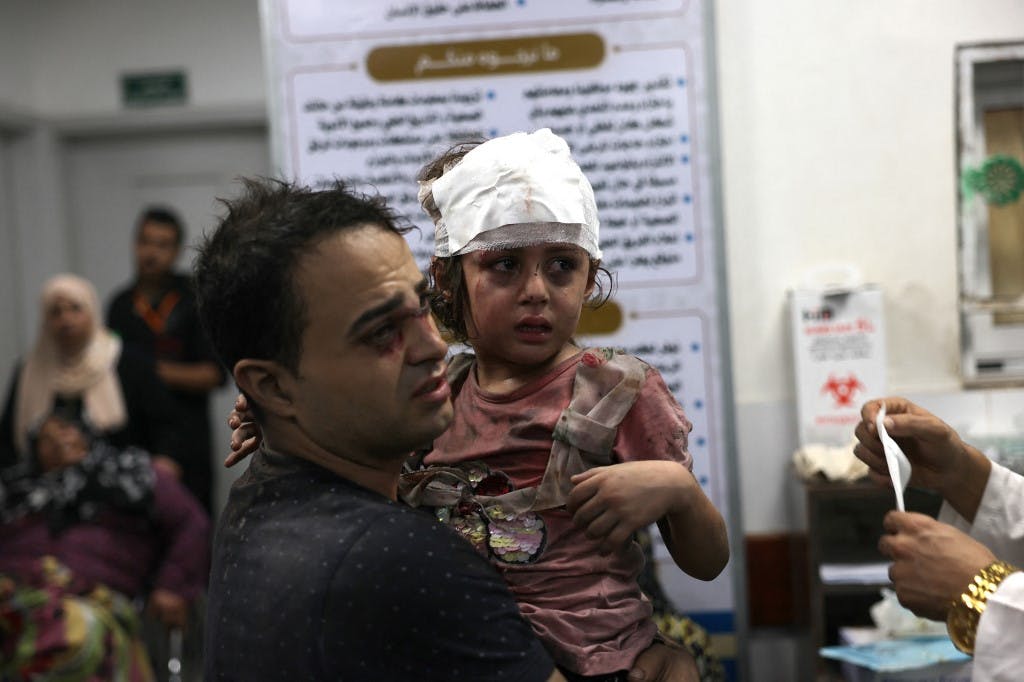 یک مرد فلسطینی پس از حمله هوایی اسرائیل به خانه‌ای در رفح در جنوب نوار غزه در ۳۰ اکتبر ۲۰۲۳ دختر مجروح خود را به بیمارستان ابو یوسف النجار برده است. (عکس از سید خطیب / خبرگزاری فرانسه)