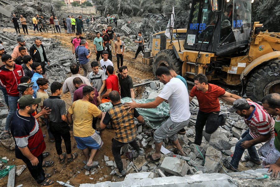 گروهی از مردم شهر رفح در جنوب نوار غزه جنازه‌ای را از زیر آوار یک خانه پس از بمباران اسرائیل بیرون می‌کشند.