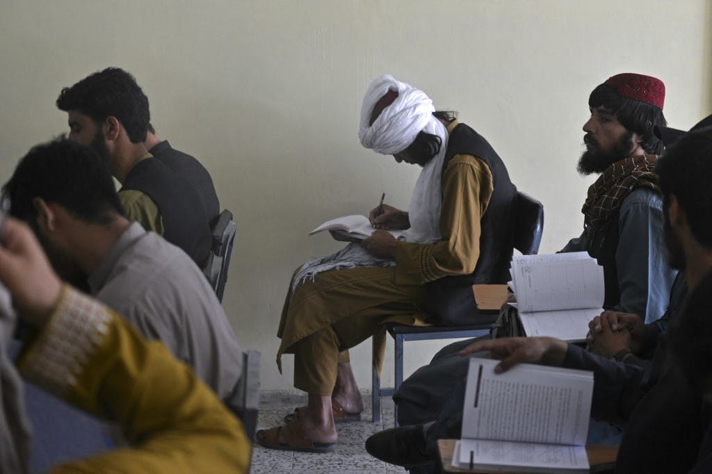 یک کلاس دانشگاهی در افغانستان. یکی از اعضای طالبان به عنوان دانشجو در جمع دانشجویان دیده می‌شود.