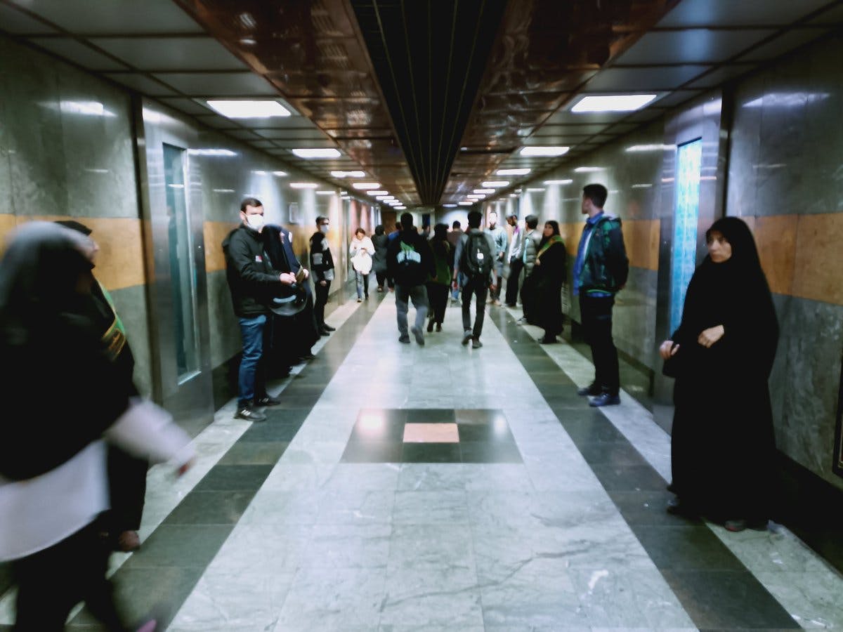 راهروی متروی انقلاب تهران - در دوسمت راهرو ماموران زن و مرد نیروی انتظامی مستقر شده‌اند و یک تونل را شکل داده‌اند که شهروندان باید برای رسیدن به جایگاه سوارشدن از آن عبور کنند.