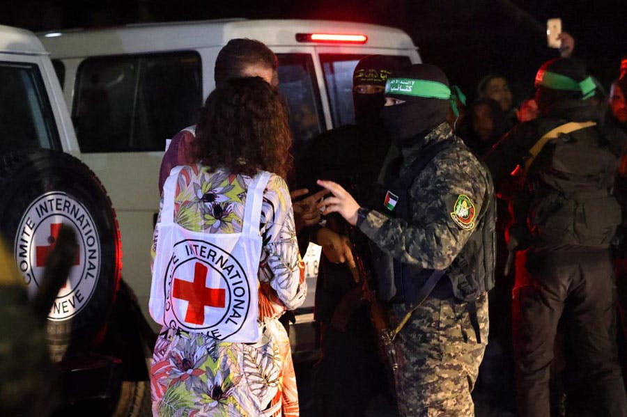 در این تصویر افراد مسلح حماس و جهاد اسلامی چهره خود را پوشانده‌اند و با روبان‌هایی بر سر در کنار چند آمبولانس با یک زن از کارمندان صلیب سرخ در حال گفت‌وگو هستند. در پسزمینه‌ی تصویر مردم در سیاهی شب ایستاده‌اند.