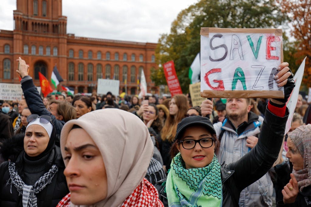 زنی پلاکاردی در دست دارد و روی آن نوشته: «غزه را نجات دهید»