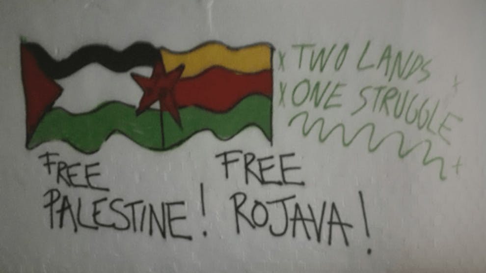 گرافیتی روی دیوار نوشته: «فلسطین را آزاد کنید، روژآوا را آزاد کنید. دو سرزمین، یک سرنوشت»