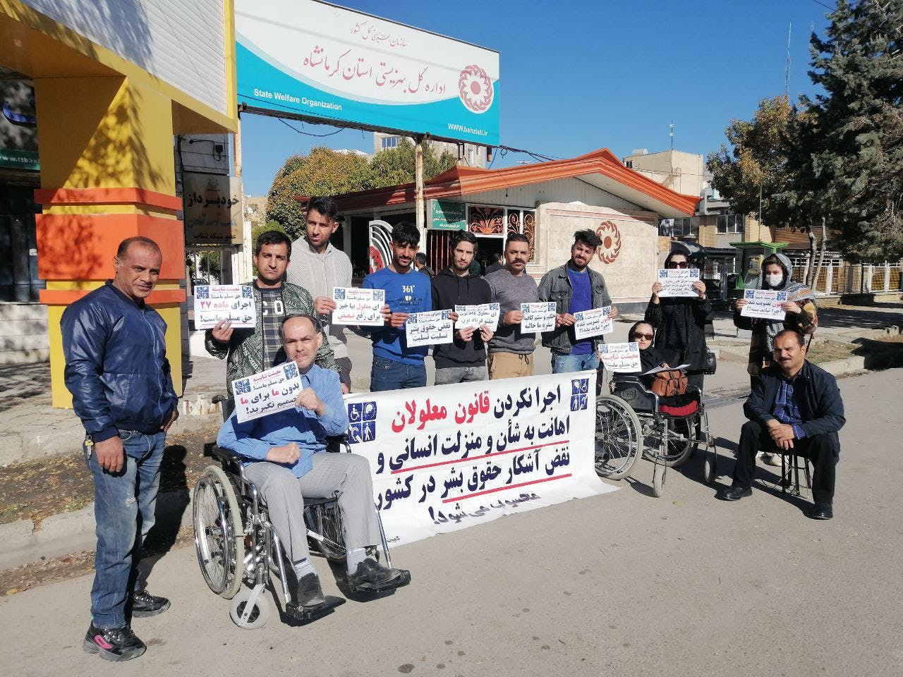 تجمع اعتراضی معلولان در شهرهای مختلف. بر روی یک بنر نوشته شده است اجرا نکردن قانون معلولان اهانت به شان و منزلت انسانی و نقض آشکار حقوق بشر در کشور است.