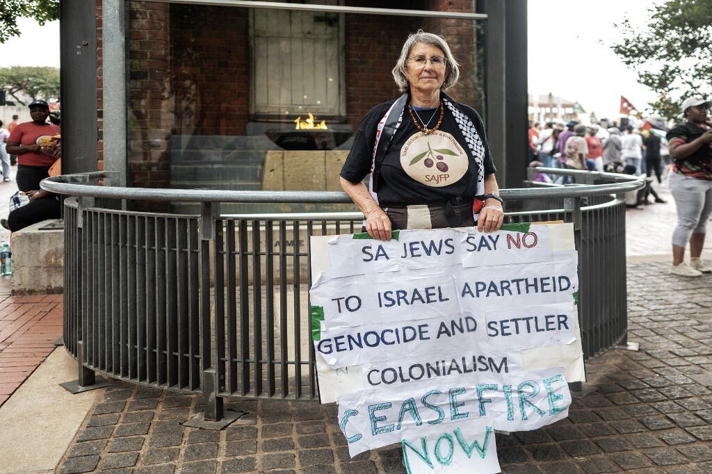 زنی با نوشته‌ای اعتراضی در دست