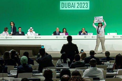 تصویر یک اکتیویست در کنفرانس اقلیمی که در حال اعتراض به لابی گرهای سوخت فسیلی است