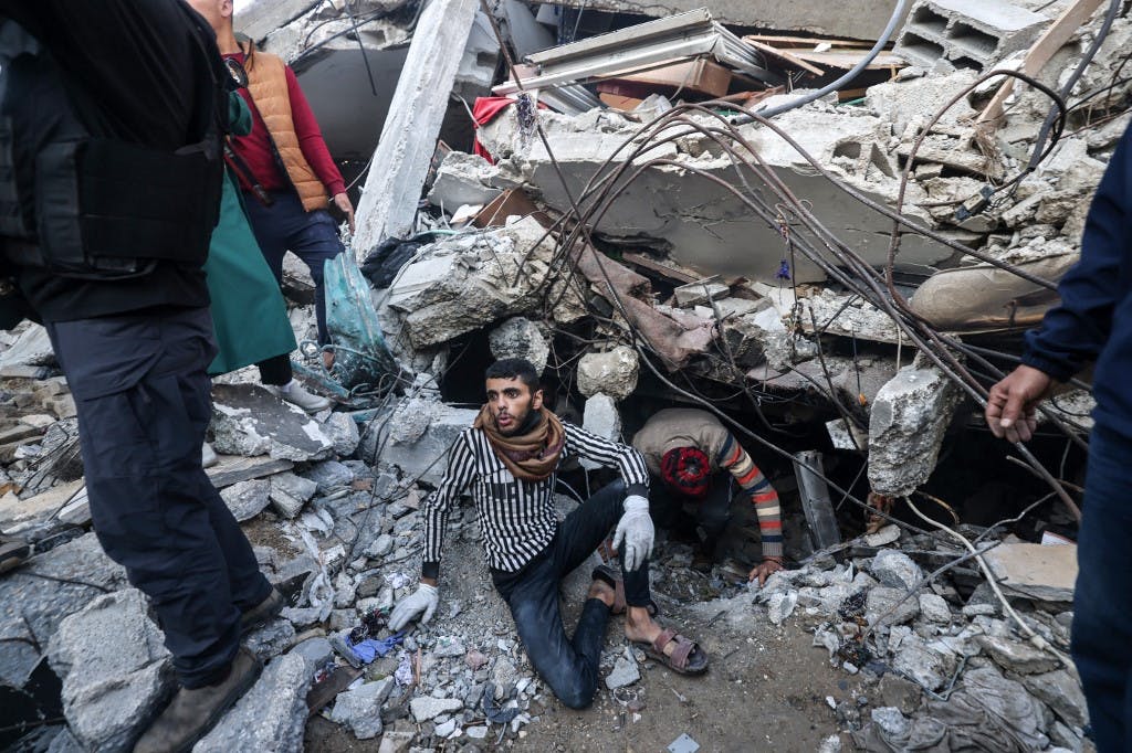 فلسطینیان در بحبوحه نبردهای ادامه دار بین اسرائیل و گروه شبه نظامی فلسطینی حماس، آوارهای ساختمانی را که در پی بمباران اسرائیل در رفح در جنوب نوار غزه در ۱۵ دسامبر ۲۰۲۳ تخریب شده بود، جستجو می‌کنند. (عکس از MOHAMMED ABED / AFP)