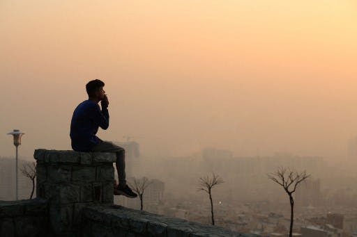 تصویر خبرگزاری فرانسه از آلودگی هوای تهران: یک نفر را در ارتفاعات شما تهران در حال تماشای وضعیت جهنمی آلودگی هوای پایتخت ایران نشان می‌دهد.
