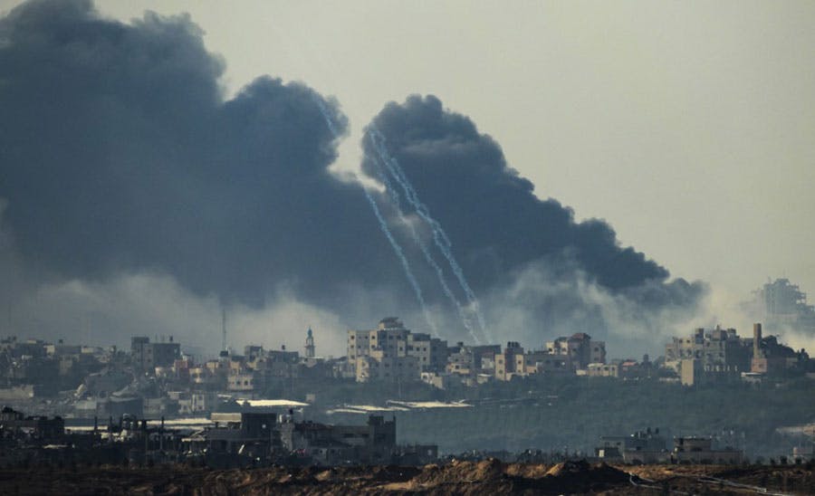 این تصویر نمای دوری از جنوب اسرائیل در نزدیکی مرز با غزه را نشان می‌دهد که دود از ساختمان‌های غزه بلند شده است.