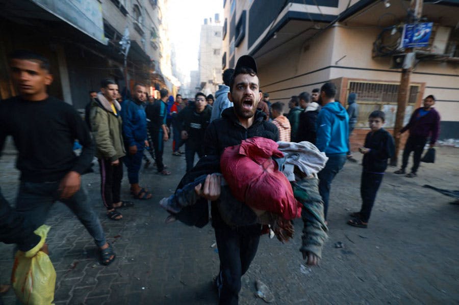 یک مرد فلسطینی کودکی را که به‌نظر می‌رسد زخمی یا کشته شده است در آغوش گرفته و سراسیمه و در حال فریاد می‌گریزد.
