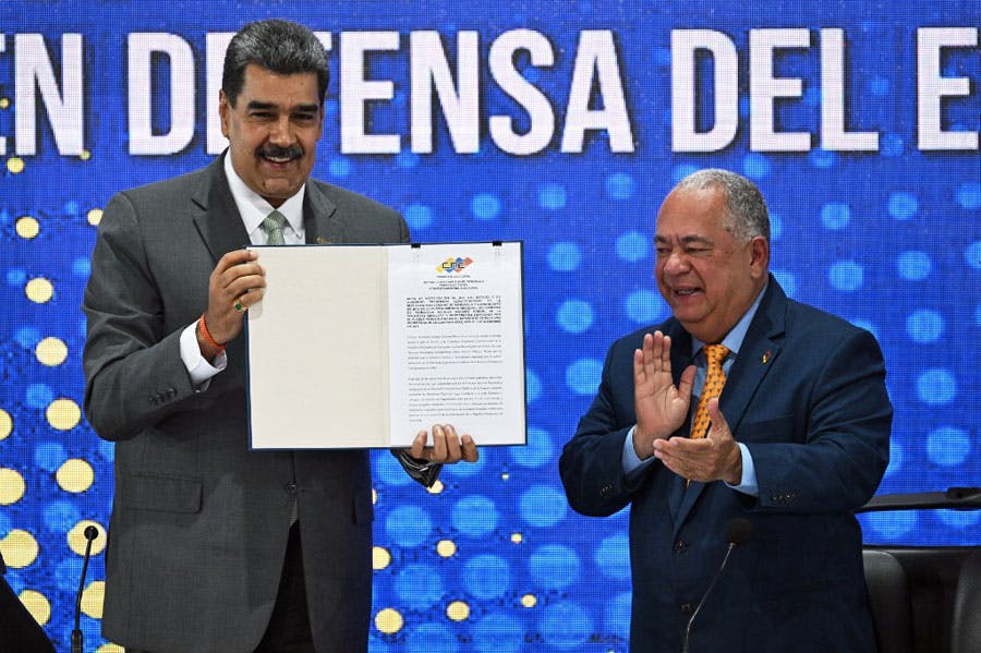 نیکلاس مادورو، رئیس جمهوری ونزوئلا در کنار الویس آموروسو رئیس شورای ملی انتخابات ونزوئلا در حالی‌که می‌خندند سند حاکمیت ونزوئلا بر منطقه اسکیبو گویان را نشان می‌دهند. سند در دست مادورو است.