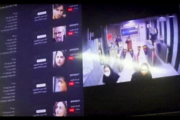در تصویر چهره‌های شهروندان مشهدی با مشخصات در کنار تصویر عمومی از سالن مترو ایستگاه شریعتی مشهد بر روی مانیتور دیده می‌شود.