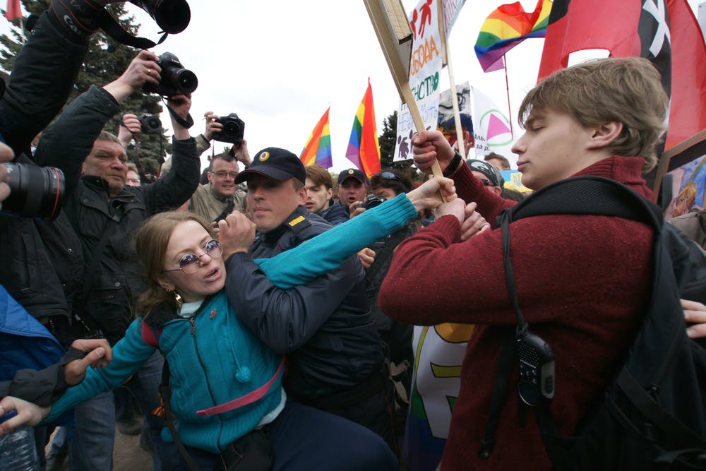 تصویر شاتر استاک از پراید ۲۰۲۱ شهر سنت پیترزبورگ در روسیه. در این تصویر یک فرد هموفوب، در تلاش است تا پرچم احتمالا رنگین‌کمان را از دست یک نفر از افراد جامعه‌ال‌جی‌بی‌تی بیرون بکشد.
