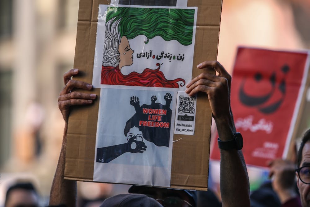 تصویر تزئینی از شاتر استاک یک راهپیمایی ضد جمهوری اسلامی را در شهر ونکوور کانادا نشان می‌دهد که در آن یک نفر تابلوی «زن، زندگی، آزادی» را به دو زبان فارسی و انگلیسی در دست دارد.