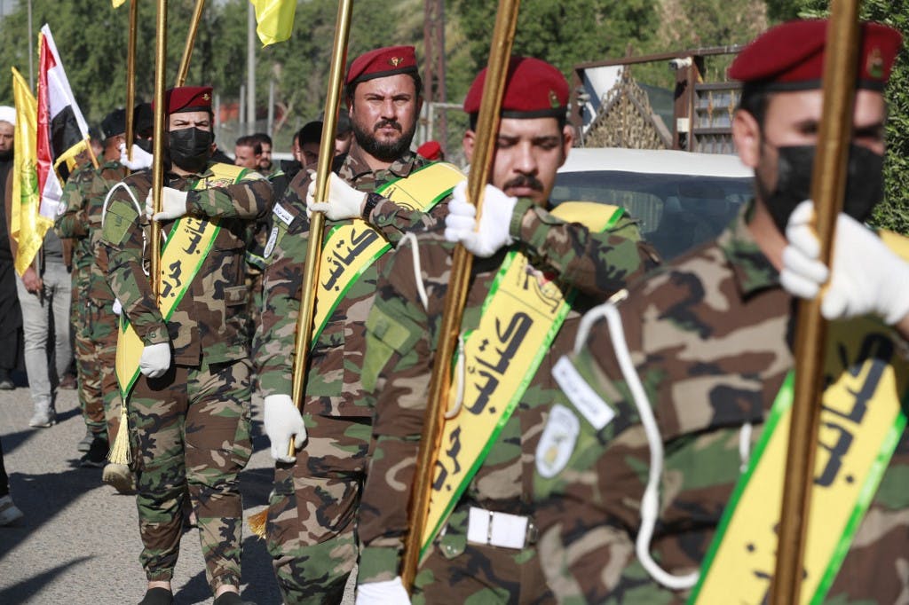نیروهای کتائب حزب‌الله عراق در حال رژه و حمل پرچم