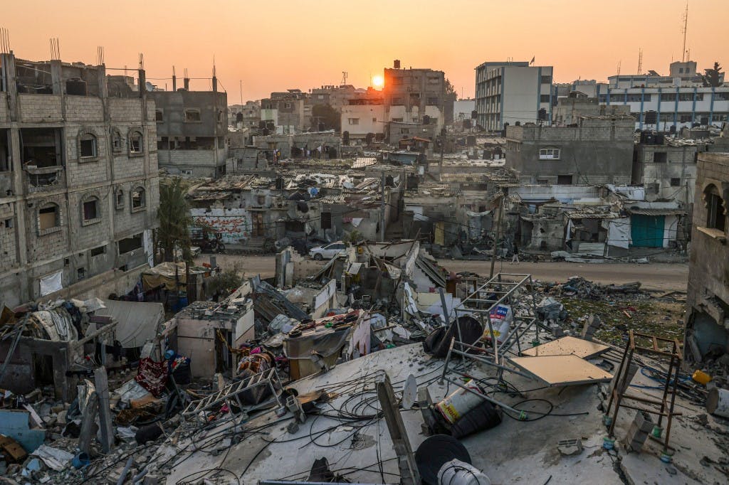 طلوع آفتاب در پس‌زمینه ویرانه‌های نوار غزه، آسمان صورتی‌رنگ است.