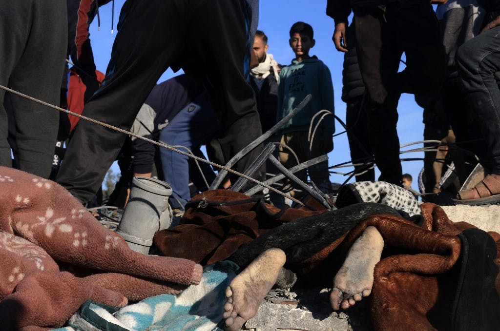 جسد یک قربانی در میان آوار خانه‌ای که از آن به عنوان پناهگاه برای یک خانواده آواره فلسطینی استفاده می‌شد. بسیاری از آن‌ها در حمله اسرائیل به رفح در جنوب نوار غزه در ۷ ژانویه ۲۰۲۴ کشته شدند (عکس از خبرگزاری فرانسه)