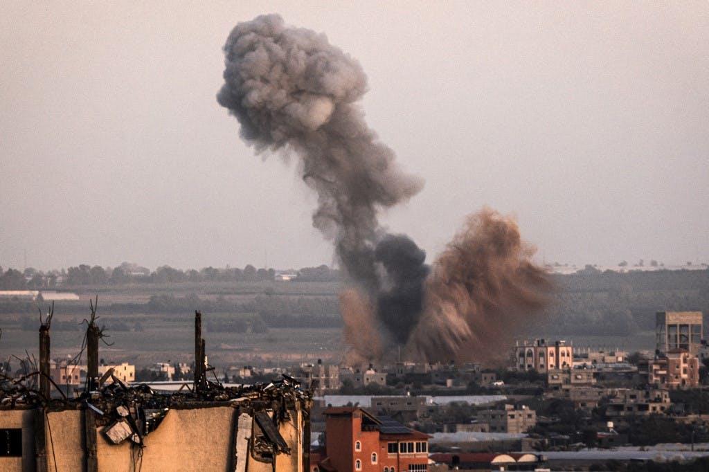 نمای شهر رفح در جنوب نوار غزه از دور. دودی خاکستری رنگ و بلند از ساختمانی به هوا رفته است.
